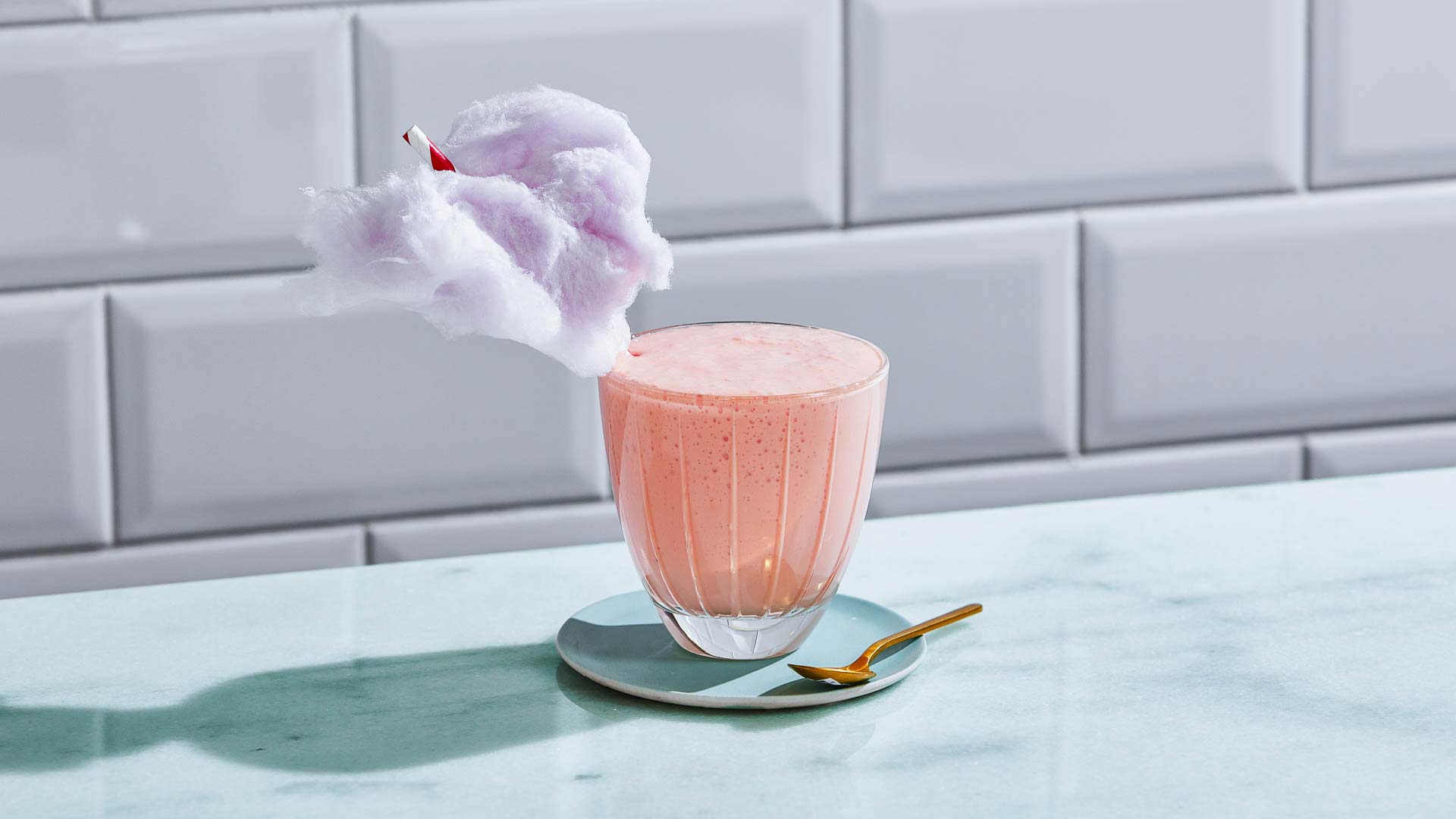 Glass of Cotton Candy Milkshake against a tiled wall