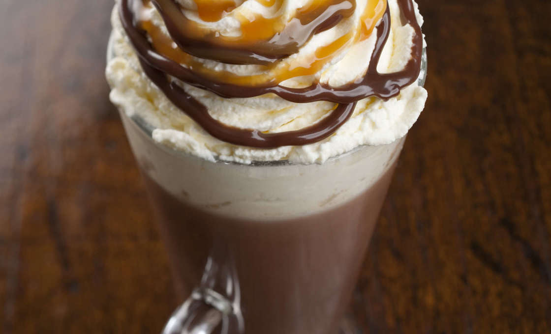 A glass of mocha irish shake on a wooden table