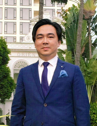 Juno Yong wearing a blue suit outside