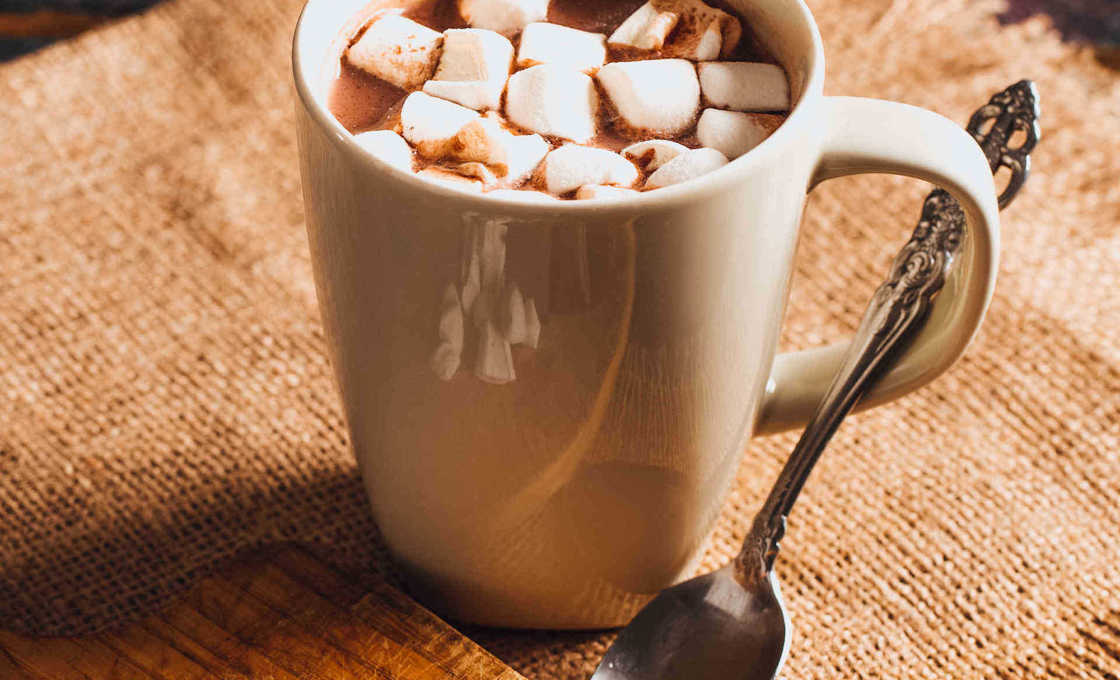 Hot Chocolate on Rustic Table with marshmallows and chocolate squares