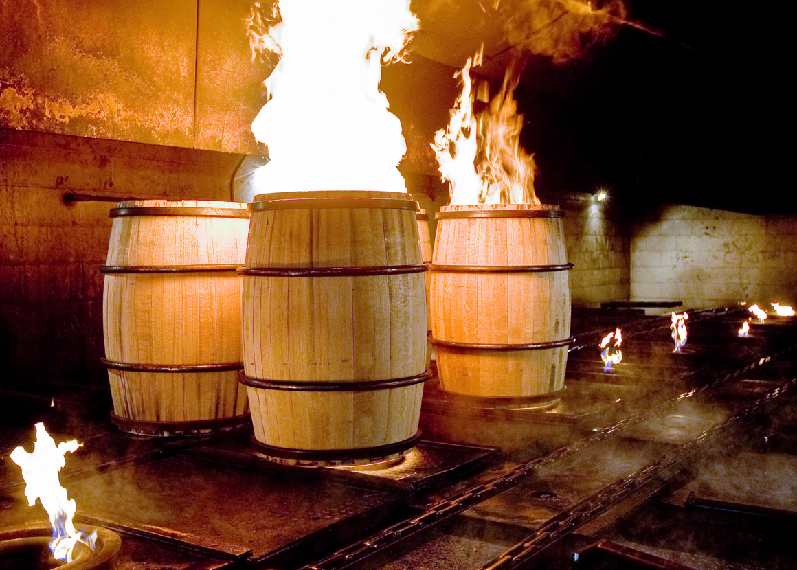 Three wine barrels with flames coming from the top of two