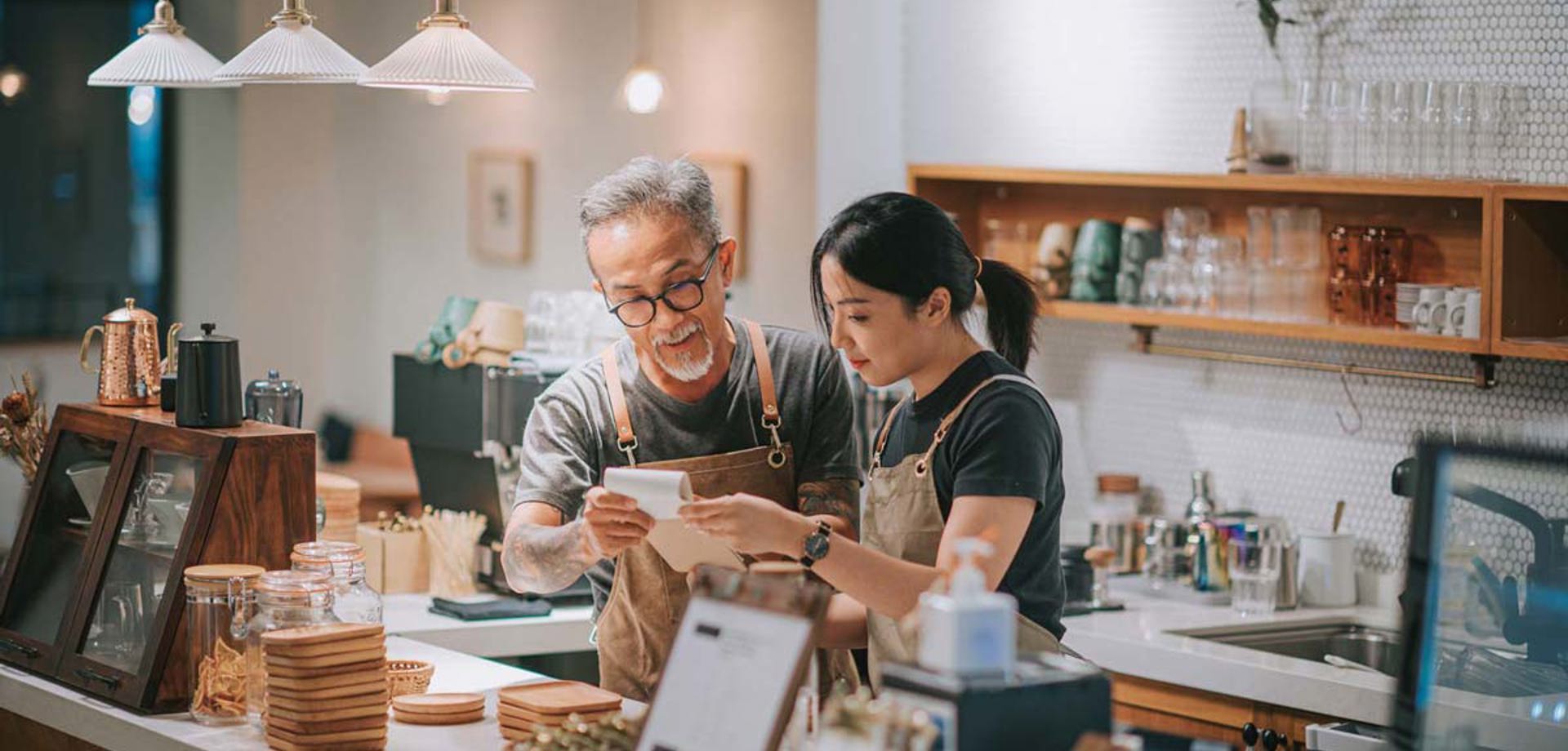 two colleagues behind coffee shop counter