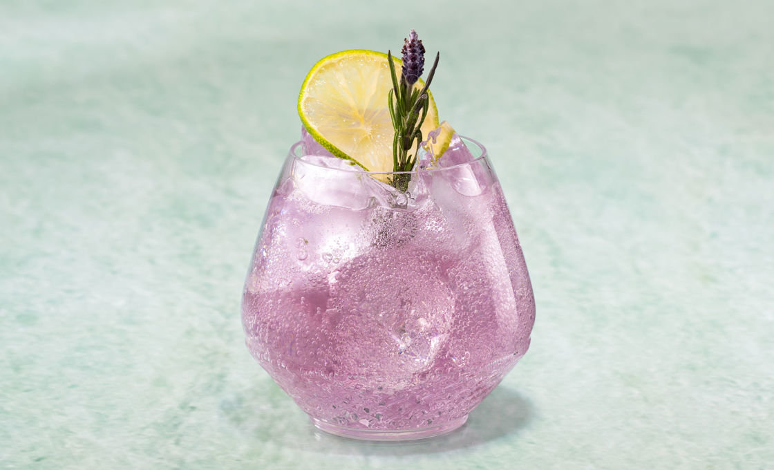 Glass of Lavendar Sonic on a green stone surface