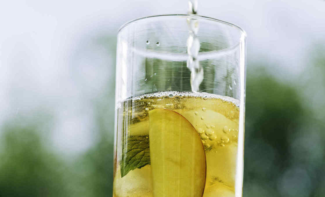 Pear And Apple Soda being poured into a glass