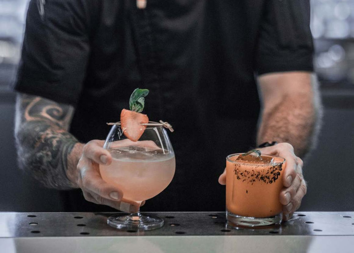 Bartender holding two drinks