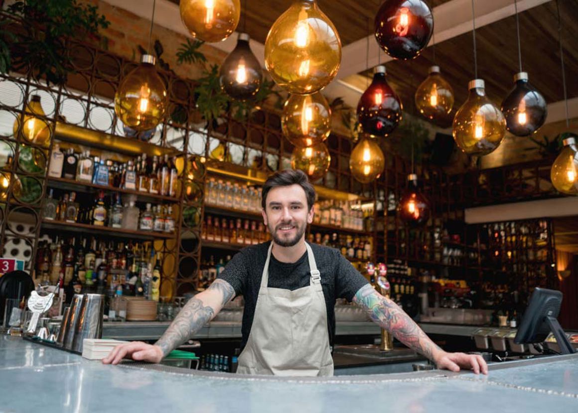 Happy business owner working at a restaurant and looking at the camera smiling