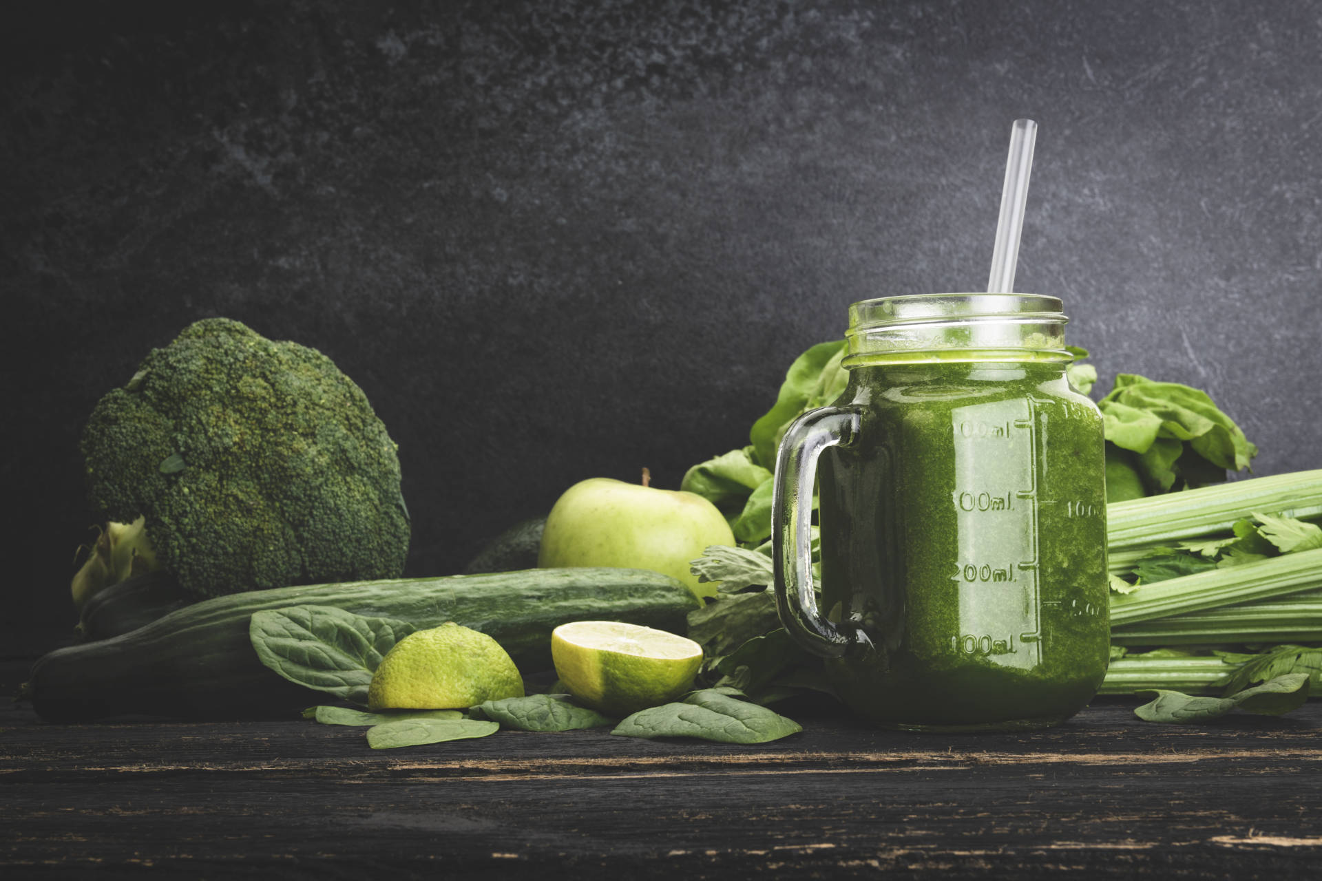 Spicy veggie smoothie with an assortment of green vegetables on a rustic table