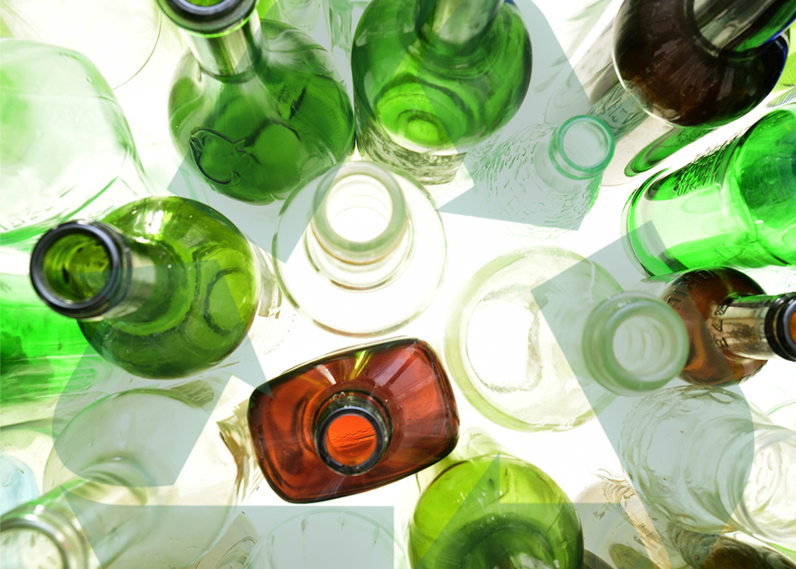 A collection of empty glass bottles in green, white and brown