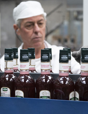 Man oversees a Mathieu Teisseire bottling line