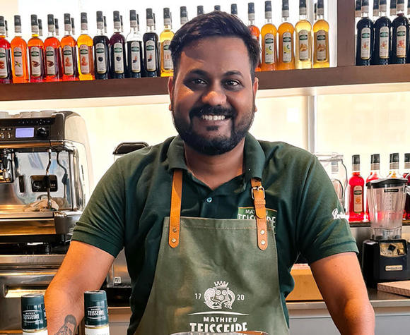 Falesh Sharma smiling with an array of cocktail making equipment